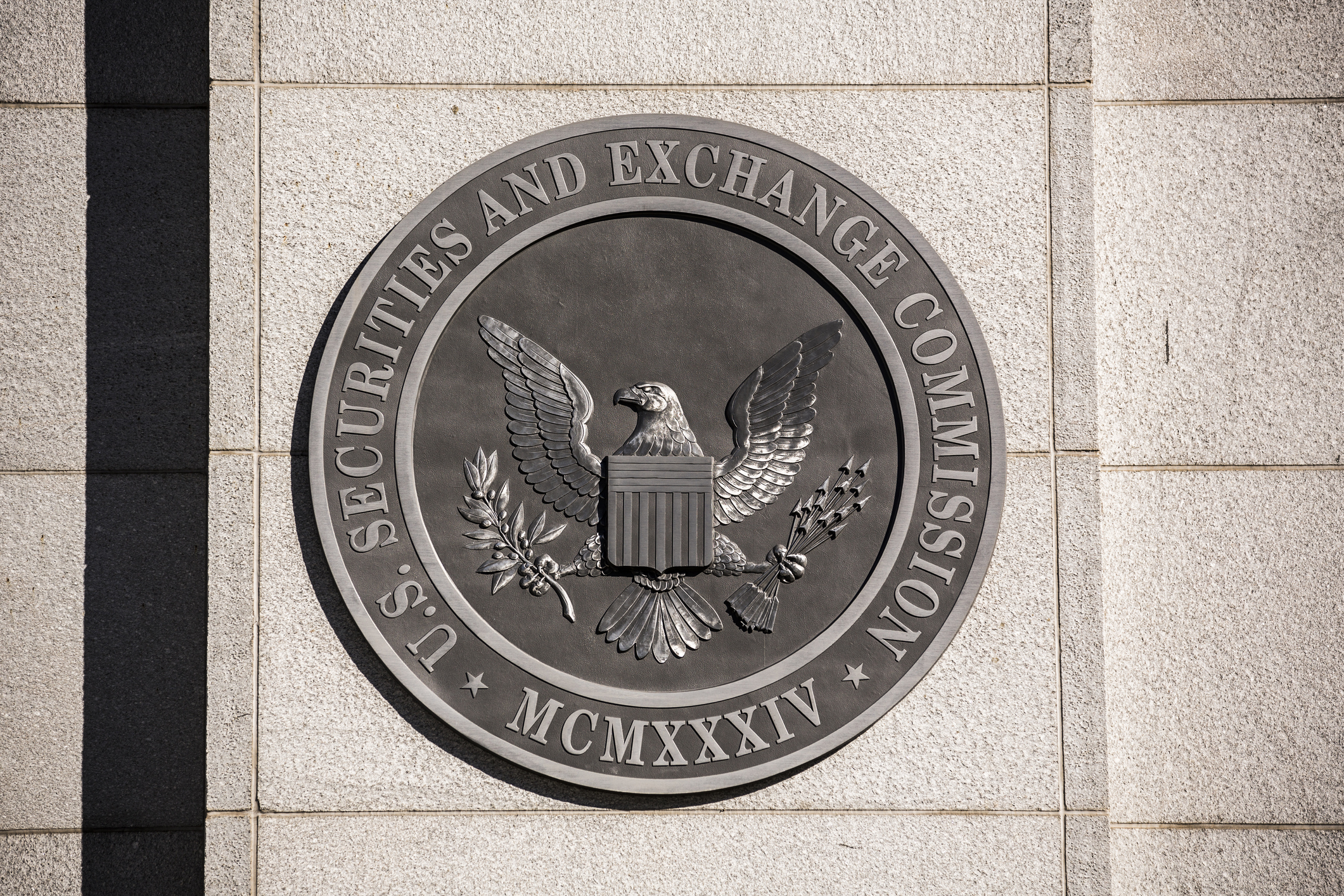 Close-up of the U.S. Securities and Exchange Commission (SEC) seal mounted on a stone wall, symbolizing financial regulation and government oversight.